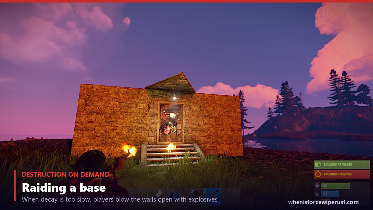 A real in-game Rust screenshot of a player firing explosive ammo at a base door to destroy it, showing how raiders break through walls and doors with explosives rather than waiting for decay